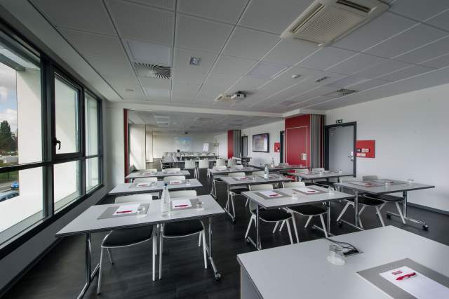 tables et chaisses dans une salle de séminaire