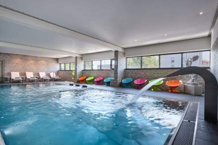 piscina con fuente de masaje y asientos de colores